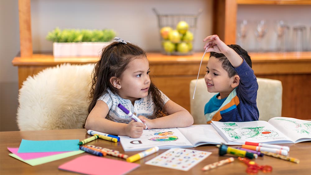 Two young children playing at a table.